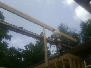 Carpenter setting a ridge beam over a new addition frame — Ice Dam Removal by Roofing Brothers in Cokeburg