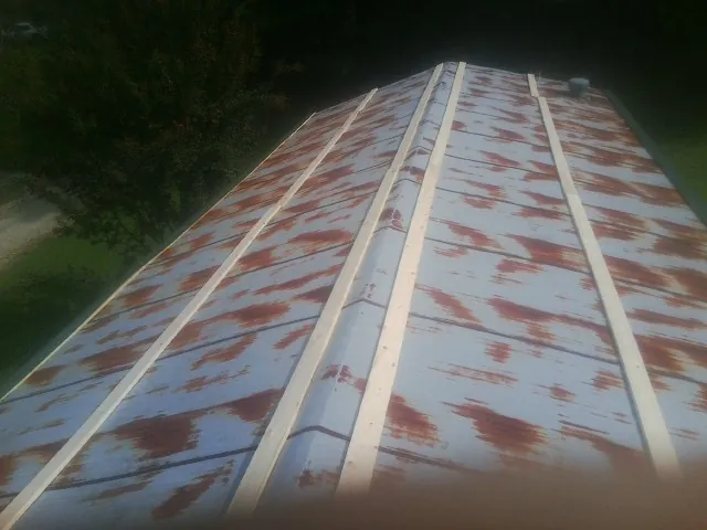 Rusted metal roof panels with new wood purlins before replacement — Storm Damage Roof Repair in Cokeburg by Roofing Brothers