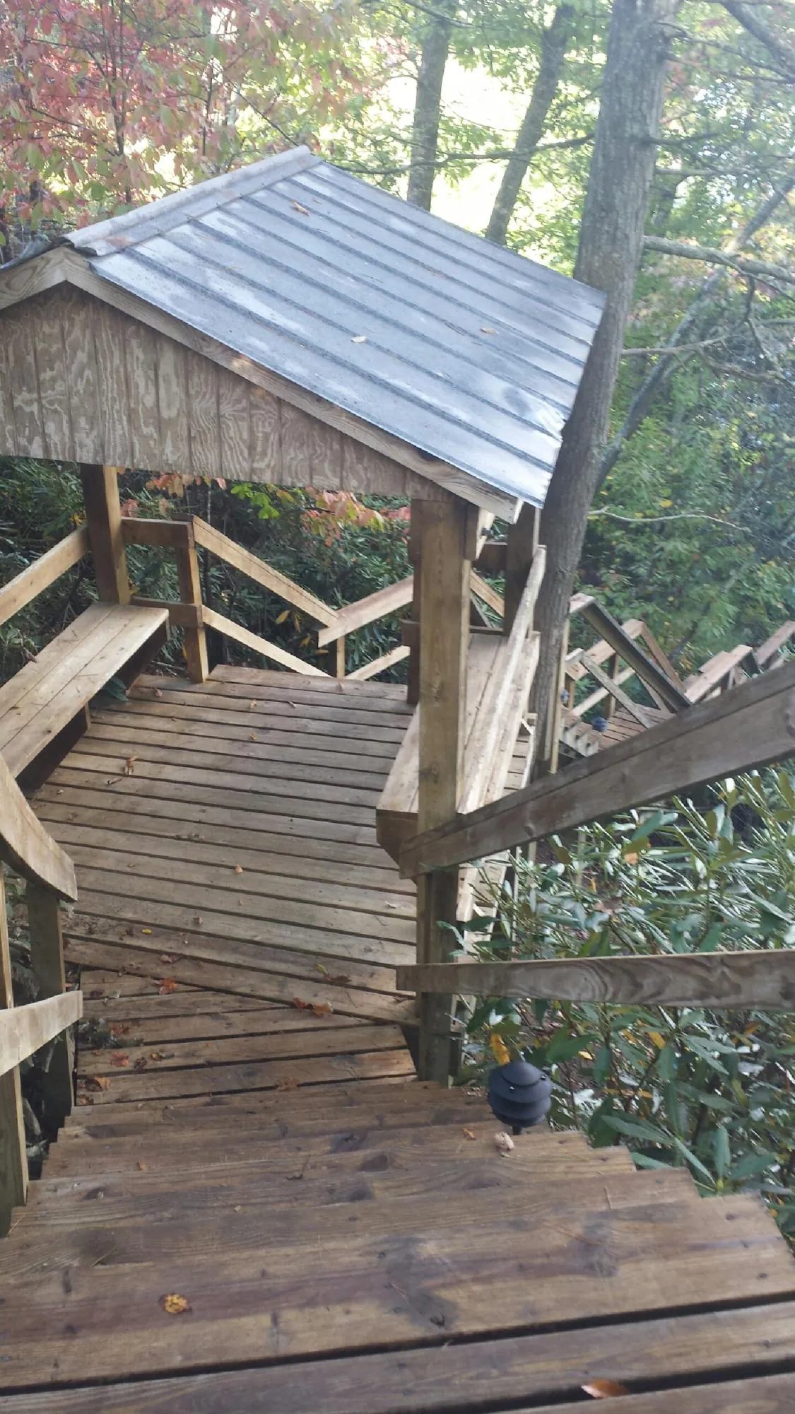 Metal roofed shelter over wooden steps on a wooded walkway — Skylight Repair & Installation work by our crew in Cokeburg
