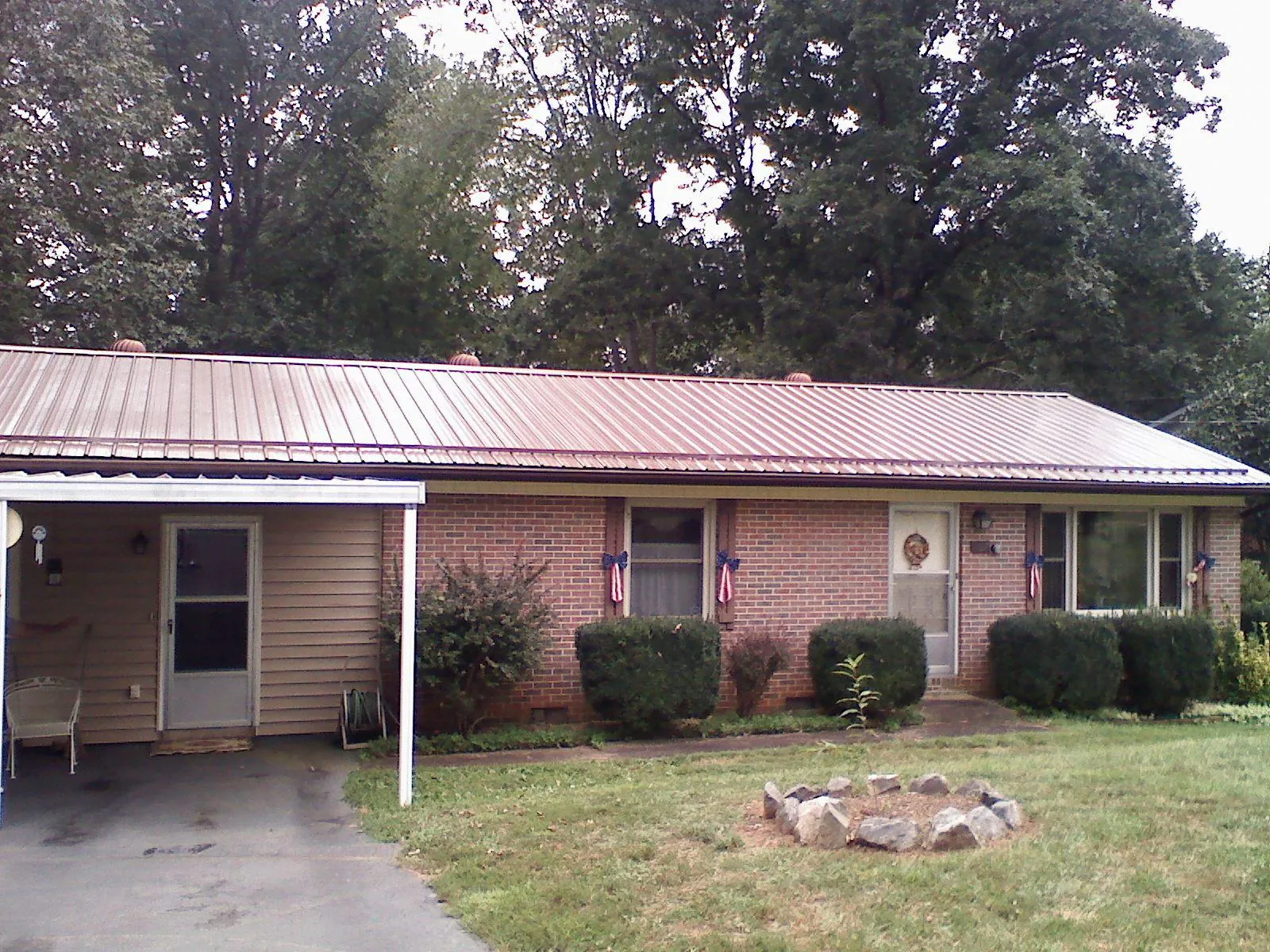 Bronze metal roof and carport on a brick ranch home — Roof Repair work by our crew in Cokeburg